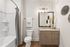 Contemporary bathroom with stylish vanity, elegant lighting, and a pristine full bath, exuding modern luxury and comfort.