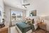 Chic bedroom with plush bed, elegant decor, and large window offering abundant natural light.