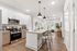 Modern open-concept kitchen with sleek appliances, stylish pendant lighting, and a cozy living area with natural light.