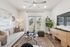 Bright and inviting living room with stylish decor, large beige couch, modern art, and natural light pouring through glass doors.