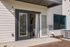 Inviting exterior view of a modern apartment with elegant French doors opening to a cozy living space bathed in natural light.