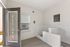 Modern pet spa with a dedicated dog wash area, sleek tiles, and large windows bringing in natural light.
