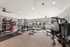 Modern, spacious gym featuring state-of-the-art fitness equipment, large windows, and abundant natural light.