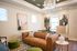 Contemporary living room with a chic brown leather sofa, modern art pieces, and elegant lighting, creating a warm and inviting space.