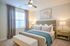 Elegant bedroom with chic decor, featuring a plush bed with soft pillows, stylish bedside tables, modern ceiling fan, and tasteful wall art, creating a serene and inviting atmosphere.