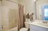 Modern bathroom with elegant design, featuring a sleek vanity, brushed nickel fixtures, and soft neutral tones.