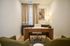 Elegant home office with a sleek wooden desk, modern art piece, and plush seating, offering a serene and productive workspace.