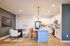 Modern open-concept kitchen and dining area with elegant lighting, featuring a spacious kitchen island, chic decor, and contemporary furniture.