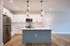 Modern kitchen with sleek stainless steel appliances, elegant white cabinetry, and chic pendant lighting over a spacious island.