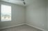 Bright and airy room with a large window and neutral color palette, perfect for a cozy bedroom or home office.