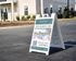 Inviting sandwich board sign outside modern apartments, advertising 'The View at Crow Creek' now leasing with an attractive pool image, ideal for new residents.