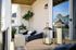 Charming patio space with elegant seating, modern lanterns, and lush greenery, perfect for relaxation and outdoor enjoyment.