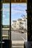 Charming view through a balcony showing elegant townhouses with modern design under a clear blue sky.
