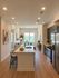 Bright and modern open-concept kitchen and living area with sleek countertops, stainless steel appliances, and cozy seating arrangement.