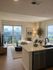 Modern living room with elegant decor, spacious seating area, and panoramic city view from large glass doors.