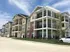 Stunning modern apartment complex with spacious balconies and elegant architecture under a clear blue sky.
