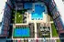 Aerial view of a vibrant apartment complex featuring a refreshing swimming pool, well-maintained tennis court, and lush green spaces, perfect for an active and relaxing lifestyle.
