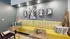Chic apartment corner with vibrant yellow seating, artistic wall decor, and modern wooden tables, perfect for a stylish and cozy ambiance.