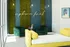 Chic lounge area featuring modern green and yellow furniture, lush moss wall design, and elegant lighting with uptown funk sign.