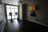 Modern fitness room equipped with two high-tech exercise bikes, wall-mounted TV, and natural light, ideal for a dynamic workout experience.