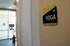 Inviting yoga room entrance with sleek signage and exercise bike in a bright, modern space.