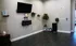 Inviting yoga nook with a mounted TV, decorative shelves, and lush greenery in a modern apartment.