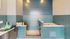 Modern pet washing station with sleek teal tiles and built-in grooming amenities.