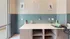 Charming pet wash station with stylish teal subway tiles, playful dog-themed decor, and ample counter space, perfect for pet lovers.