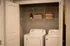 Chic laundry room featuring modern washer and dryer set, with shelving for stylish storage solutions.