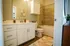 Modern bathroom with elegant fixtures, spacious vanity, and stylish tile accents exuding a warm, inviting ambiance.