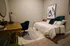 Cozy bedroom with a stylish wooden desk, elegant blue chair, and modern artwork, offering a serene and inviting ambiance.