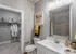 Chic and modern bathroom with elegant vanity, wall art, and a walk-in closet featuring plush robes, perfect for a luxurious lifestyle.