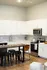 Modern kitchen with sleek white cabinets, stainless steel appliances, and a chic breakfast bar with stylish seating.