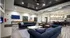Elegant open-concept living room with plush navy sofas, stylish decor, and a modern kitchen with bar seating, perfect for entertaining.