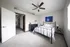 Bright and airy bedroom with modern decor, featuring a stylish metal bed, elegant dresser, and soothing wall art, complemented by natural light and a ceiling fan.