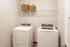 Sleek laundry room featuring a modern washer and dryer set with convenient shelving for storage.