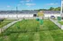 Charming pet-friendly apartment complex featuring a fenced dog park with play equipment and lush greenery.
