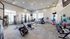 Bright, modern fitness center with state-of-the-art equipment, including treadmills, exercise bikes, and weights, offering a vibrant and invigorating workout environment.