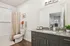 Modern bathroom featuring elegant granite countertops, stylish cabinetry, and a pristine white bathtub with a decorative curtain.