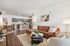 Modern open-concept living area with cozy brown leather sofa, chic dining set, and sleek kitchen featuring gray cabinets and stainless steel appliances.