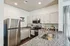 Modern kitchen with sleek granite countertops, stainless steel appliances, and elegant light cabinetry, creating a bright and inviting cooking space.