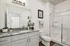 Elegant bathroom with a modern granite countertop, large mirror, and sleek glass-enclosed shower.