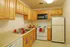 Inviting kitchen with warm wooden cabinets, modern appliances, and cozy dining setup.