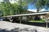 Charming apartment building with convenient covered parking nestled among lush green trees.