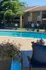Inviting apartment complex pool area with comfortable lounge chairs, vibrant landscaping, and serene surroundings.