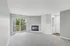 Bright and inviting living room with plush carpeting, sleek built-in fireplace, and large sliding glass doors opening to a private balcony.