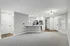 Modern open-concept apartment showcasing a sleek kitchen with stainless steel appliances, elegant lighting, and inviting living space with plush carpeting.