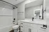 Sleek modern bathroom with elegant black fixtures, white cabinetry, and a spacious bathtub, perfect for relaxation.