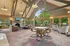 Spacious and inviting lounge area with vaulted ceilings, cozy fireplace, and large windows offering serene garden views.