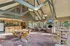 Inviting open-concept living area with vaulted ceilings, modern kitchen, cozy fireplace, and large windows offering abundant natural light.